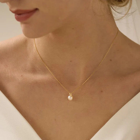 Side view of a model wearing the Minimalist Pearl Pendant, highlighting its delicate, minimalist style and timeless appeal.