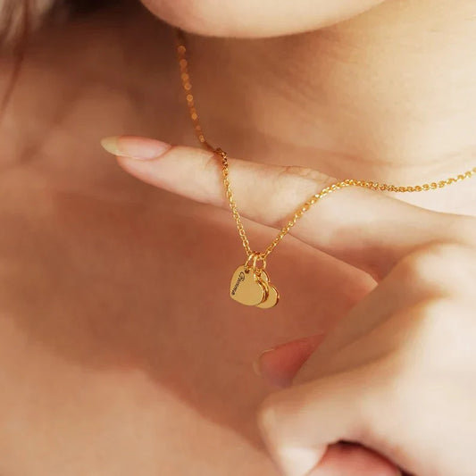 Close-up of a model wearing the Eraya Jewel Custom Heart with Family Name pendant, clearly showing the engraved family name on the delicate heart