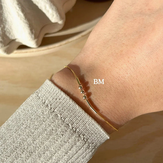 lose-up of the Eraya Jewel Elegant Custom Morse Code Bracelet in gold plated finish, showcasing the subtle dots and dashes representing a personalized message.