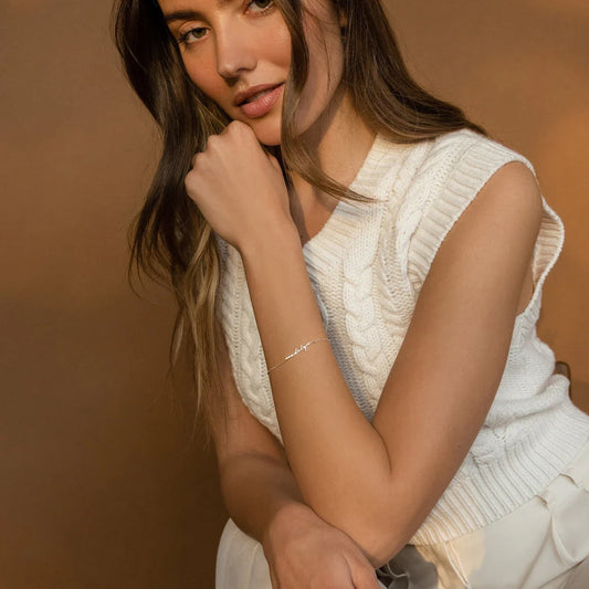 Model's wrist adorned with an Eraya Jewel Dainty Name Bracelet in Silver, emphasizing its delicate and personalized charm.