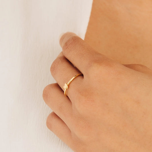 Model's finger wearing the delicate Minimalist Tiny Heart Ring, highlighting simple elegance.