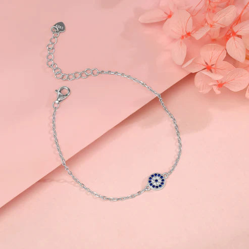 Close-up of the Eraya Jewel 925 sterling silver evil eye bracelet, detailing the intricate blue and white evil eye charm and the polished silver chain on a neutral background.