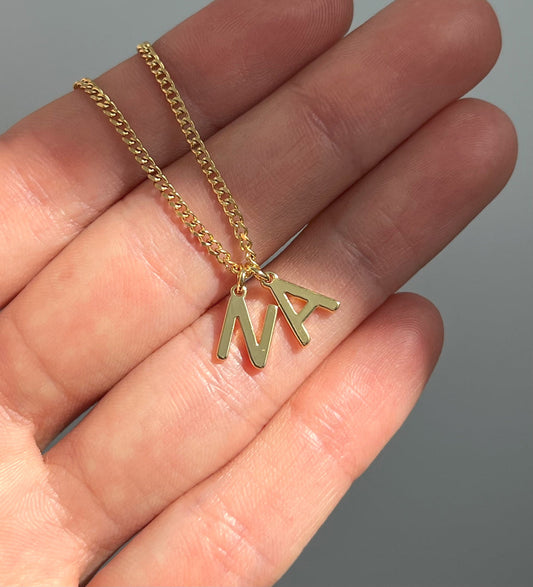 Minimalist initial necklace styled on soft hand