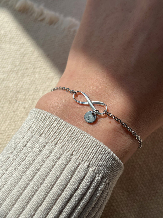 Model wearing silver infinity initial bracelet