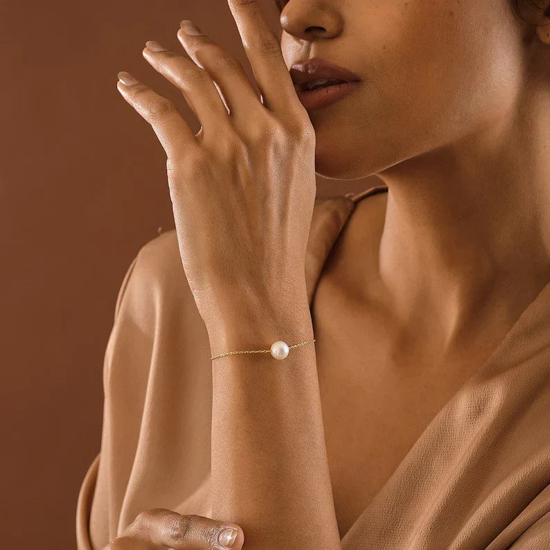 Model wearing the delicate Eraya Jewel Single Pearl Bracelet in Gold Polish