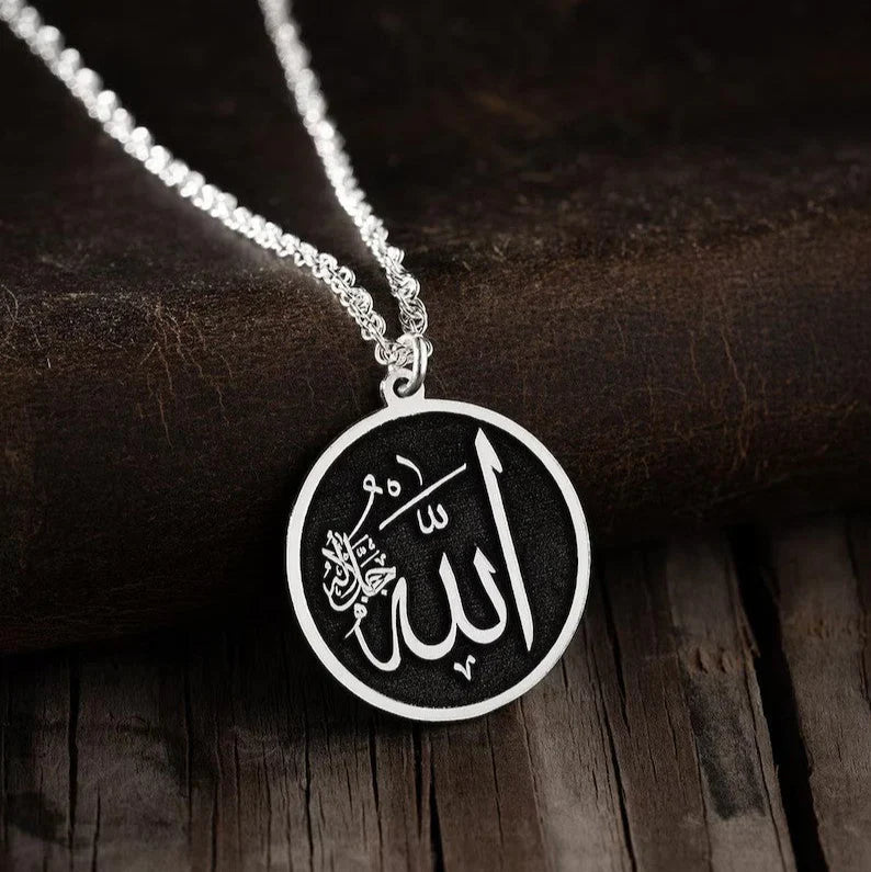 Close-up of the Noor Al-Iman Pendant showcasing intricate Arabic calligraphy of Allah and Prophet Muhammad (PBUH) on a polished surface