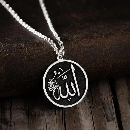 Close-up of the Noor Al-Iman Pendant showcasing intricate Arabic calligraphy of Allah and Prophet Muhammad (PBUH) on a polished surface