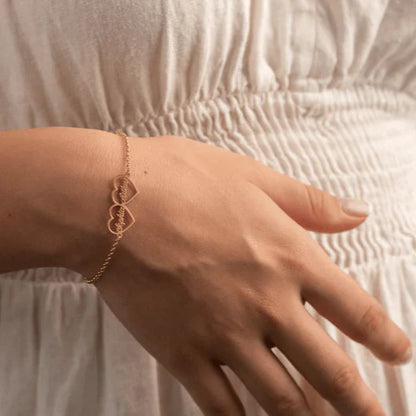 Detailed product shot of Eraya Jewel Rose Gold 'His and Hers' Heart Name Bracelets, highlighting the interconnected heart design and custom name engravings.
