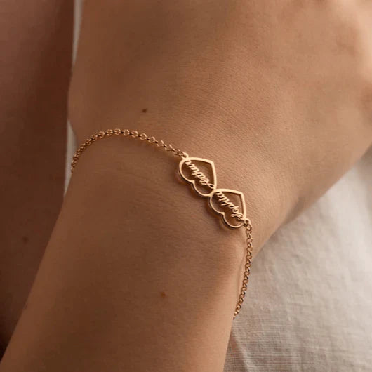 Couple models showcasing their Eraya Jewel Custom 'His and Hers' Heart Name Bracelets in Gold, a romantic personalized jewelry set.