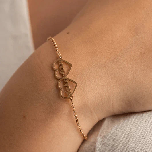 Model's wrist adorned with an Eraya Jewel Golden 'His and Hers' Heart Name Bracelet, emphasizing the custom name and elegant heart detail.