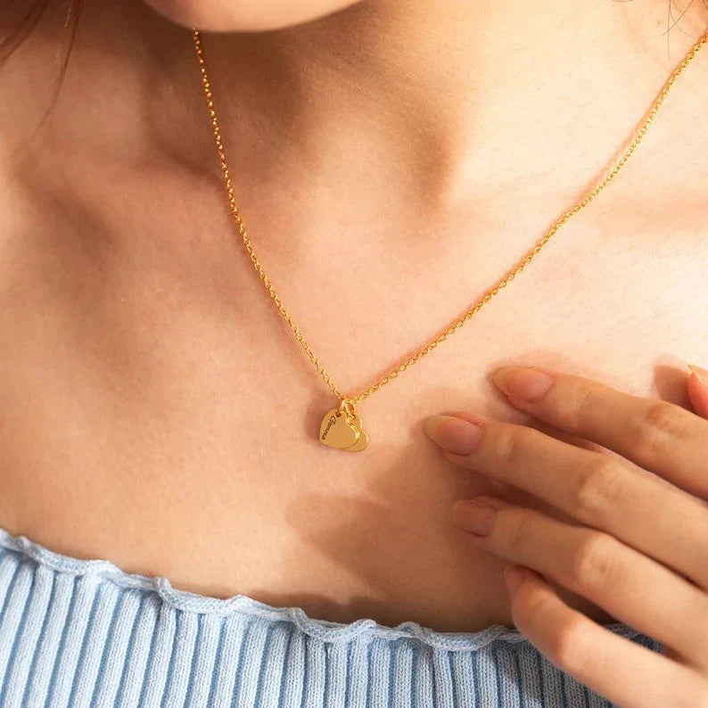 Model wearing the Eraya Jewel Custom Heart with Family Name pendant, showcasing its size and how it complements an outfit. The engraved name is subtly visible