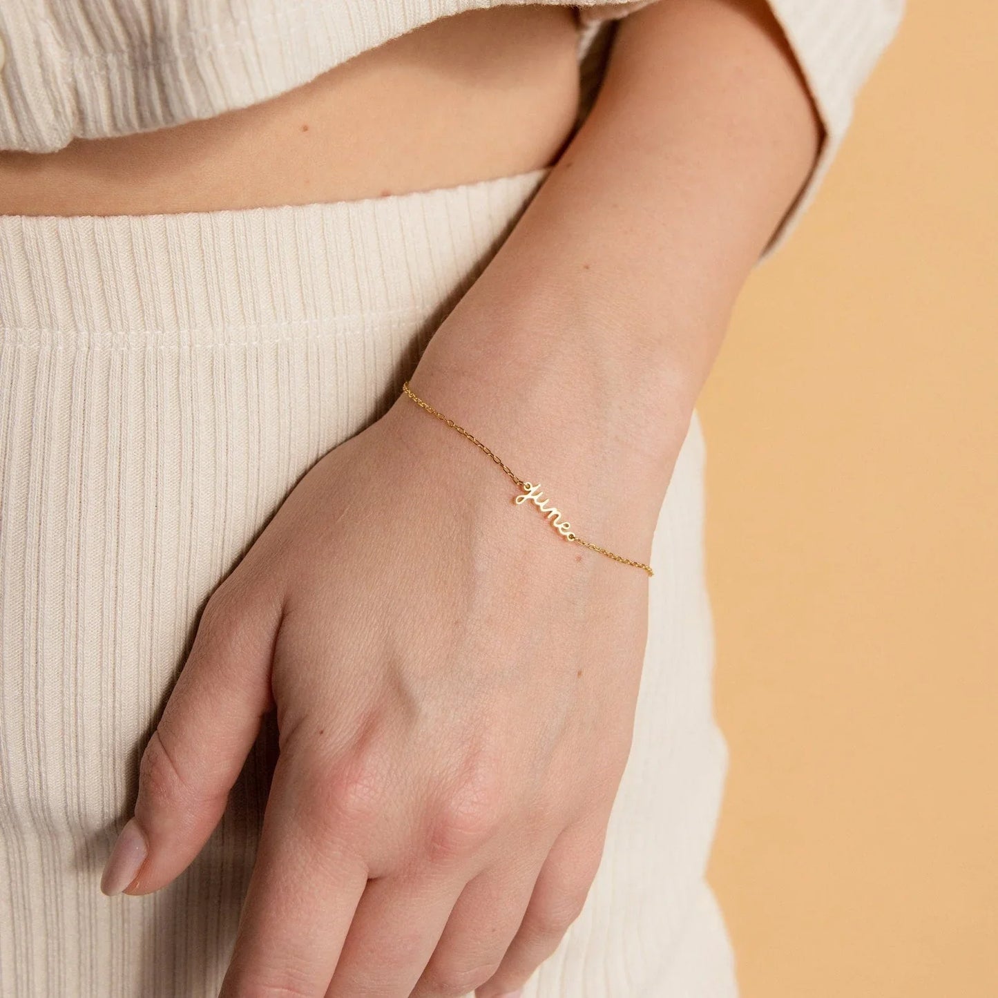 Close-up of a girl's wrist adorned with an Eraya Jewel Golden Custom Delicate Name Bracelet, highlighting the elegant personalized name script