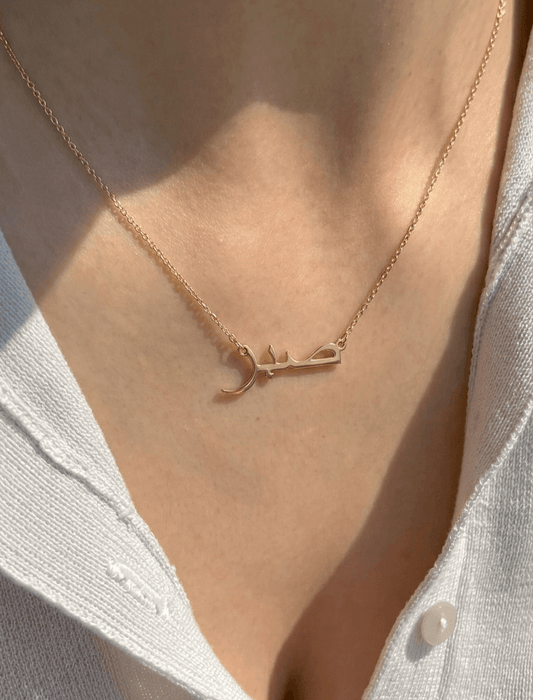 Close-up of Arabic name necklace in 22K gold finish on neck, custom Arabic script pendant on delicate chain, minimal luxury personalized jewelry erayaewel.in