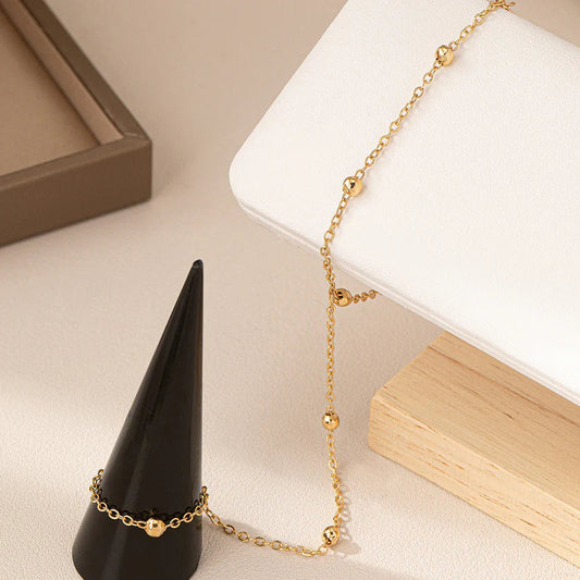 Close-up of the Golden Sheen Hand Harness, detailing its delicate gold-plated chain, bracelet, and connected ring components on a neutral background.