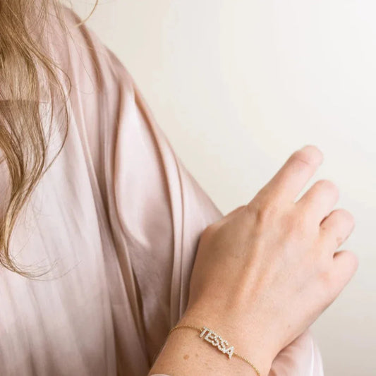 Close-up of a model's wrist showcasing the Eraya Jewel Custom Diamond Name Bracelet, its custom name intricately set with shimmering diamonds.
