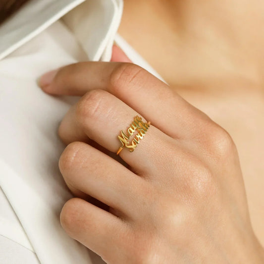 A detailed close-up showcasing the engraved names on two matching London-style rings, highlighting the craftsmanship and elegant design.