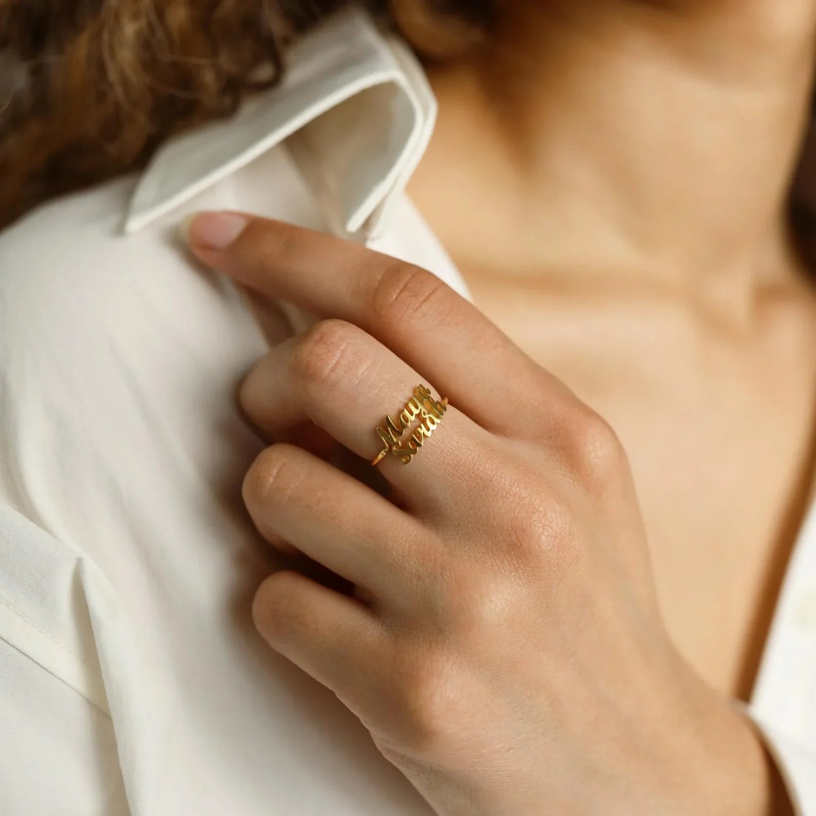 A lifestyle shot of a couple wearing the "Custom His and Hers London Name Rings," demonstrating how the rings look when worn and their symbolic connection.