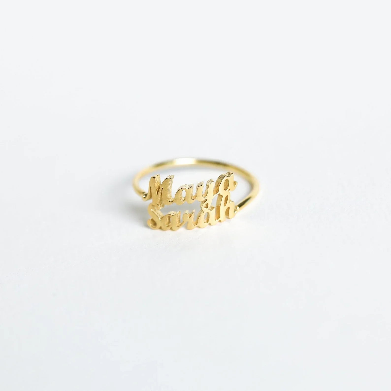 a London-inspired rings, one slightly larger than the other, each engraved with a different name, emphasizing the personalized nature of the set.