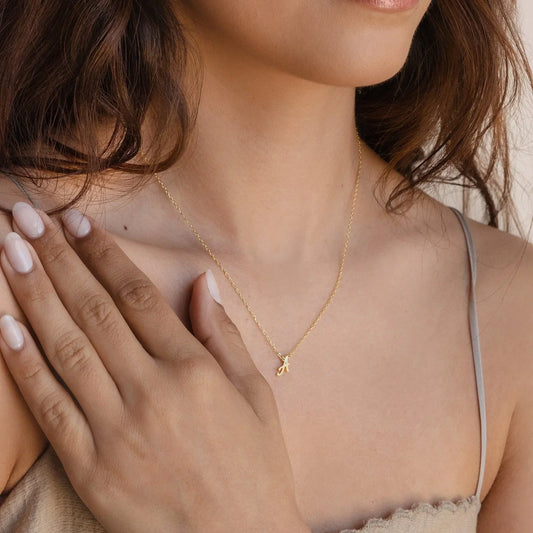 Model wearing the Eraya Jewel Initial Letter Pendant featuring the letter 'A,' showcasing its delicate design and how it complements a casual outfit.
