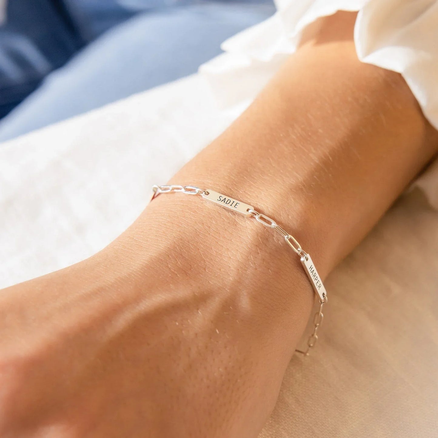 Model's wrist adorned with an Eraya Jewel Engraved Mini Name Bar Bracelet in Silver, emphasizing its delicate and personalized charm