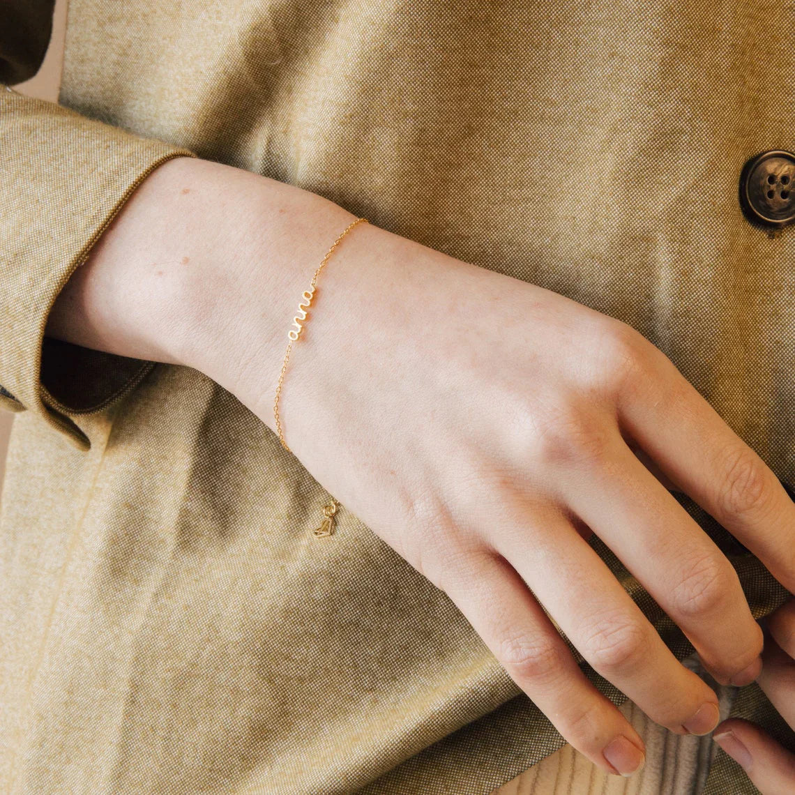 Close-up of a model wearing an Eraya Jewel Dainty Layering Name Bracelet in Silver, ideal for stacking with other pieces