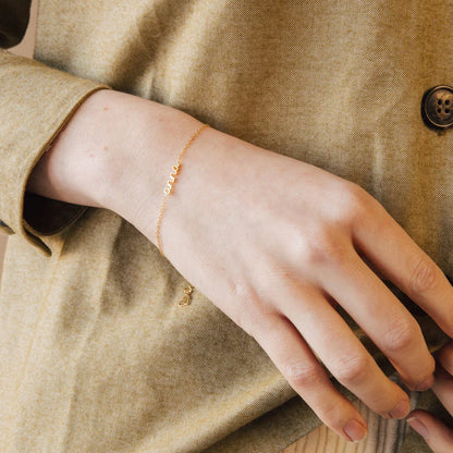 Close-up of a model wearing an Eraya Jewel Dainty Layering Name Bracelet in Silver, ideal for stacking with other pieces