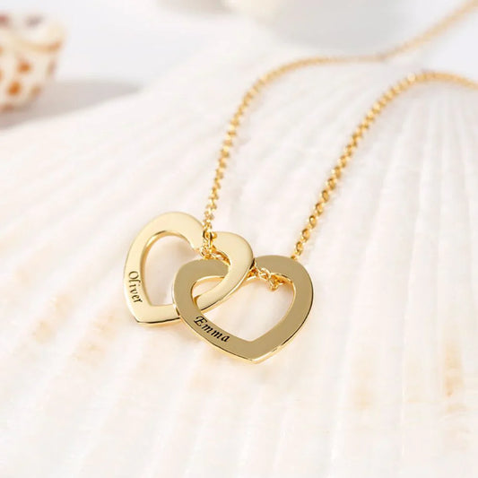 Close-up of the Twin Heart Engraved Name Necklace in gold polished finish featuring two intertwined hearts with custom engraved names