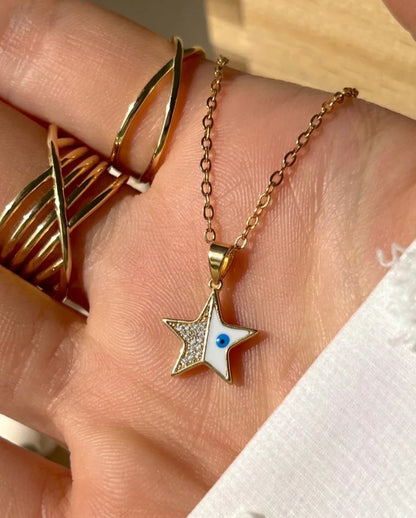 Gold necklace with a star-shaped pendant on a hand