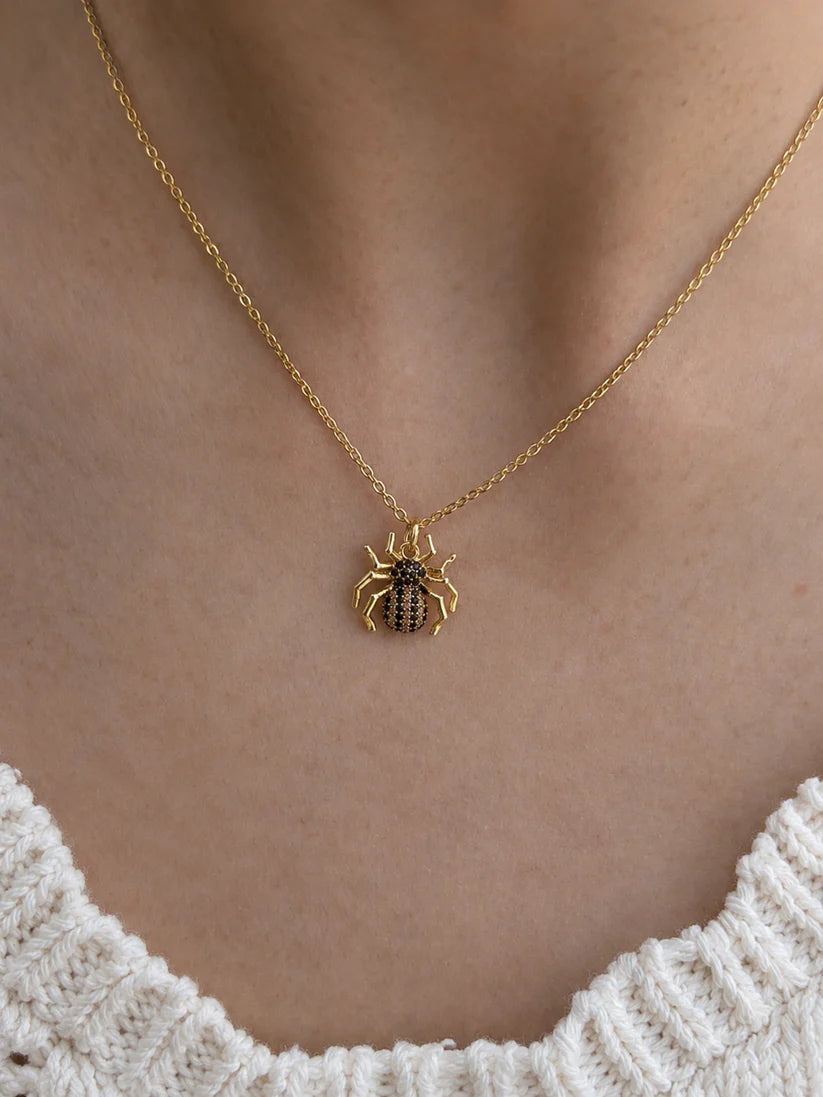 High-quality shot of a spider pendant with black and clear zircon diamonds in an 18k gold finish.