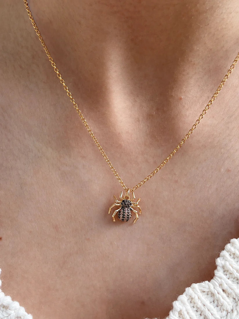 Front view of the 18k gold plated spider necklace on a model, highlighting the unique dangerous jewelry aesthetic.
