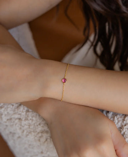 Eraya Jewel dainty birthstone bracelet worn on a woman's wrist with a pink birthstone