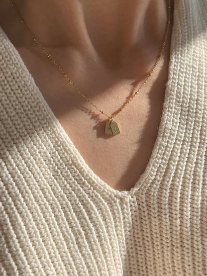 Eraya Jewel gold couple initial necklace featuring personalized tag pendants and a tiny heart charm