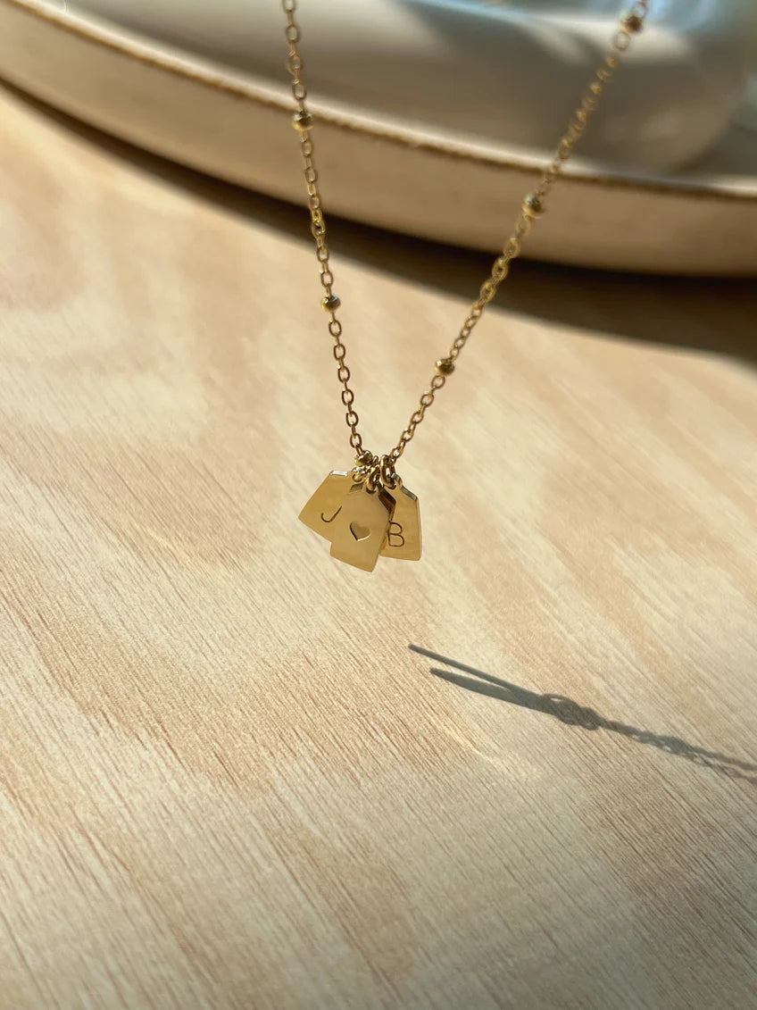 Detailed view of Eraya Jewel couple initial pendant showing personalized letters and heart charm
