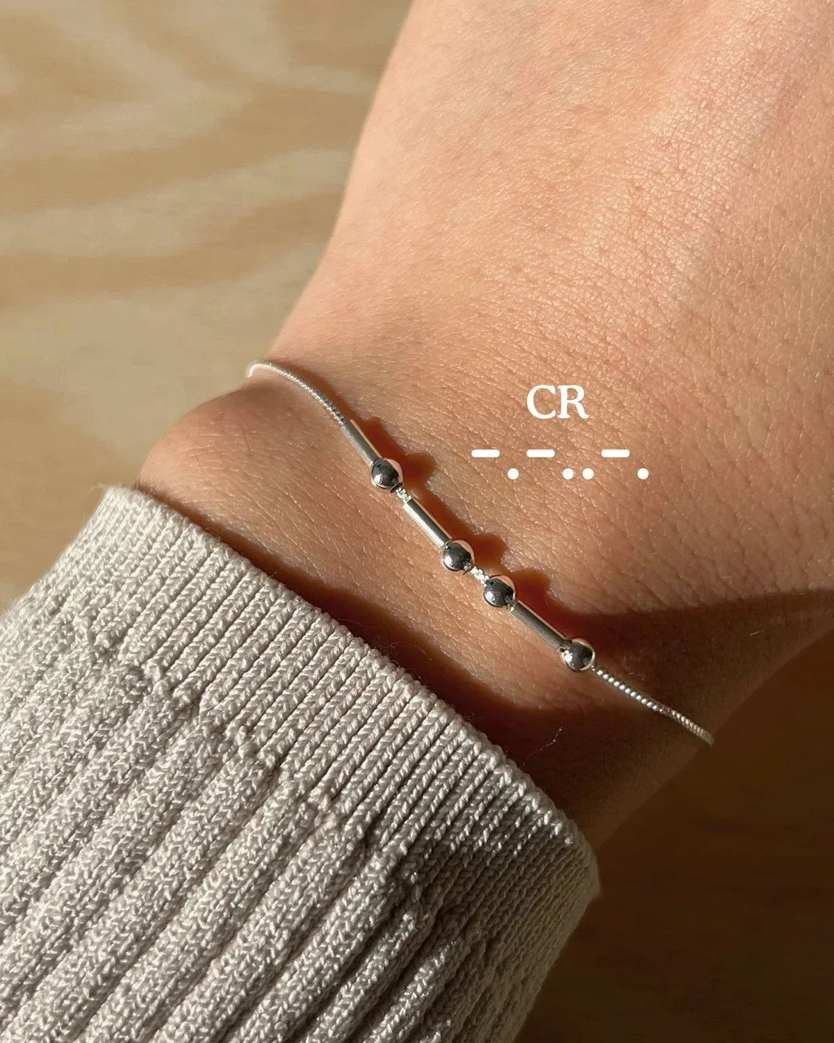 Eraya Jewel silver personalized Morse code bracelet worn on a wrist with CR encoded in dots and dashes