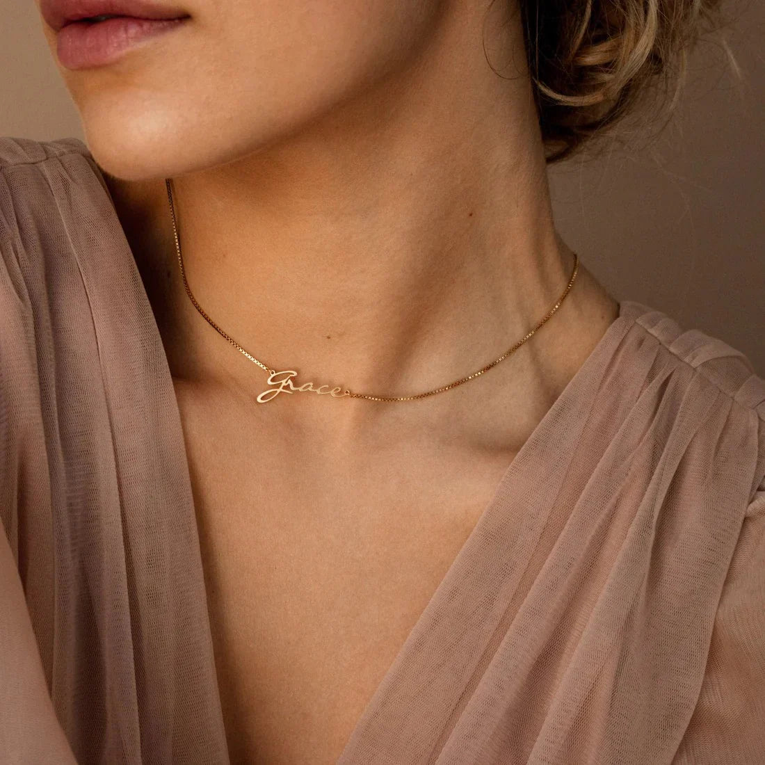 Lifestyle shot of a model wearing the Personalized Callie Signature Necklace in gold and silver, capturing its chic, modern elegance.