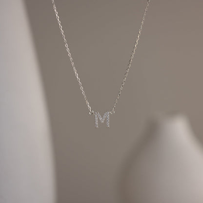 Close-up of a personalized pavé diamond initial necklace featuring a 7mm Silver letter M pendant.