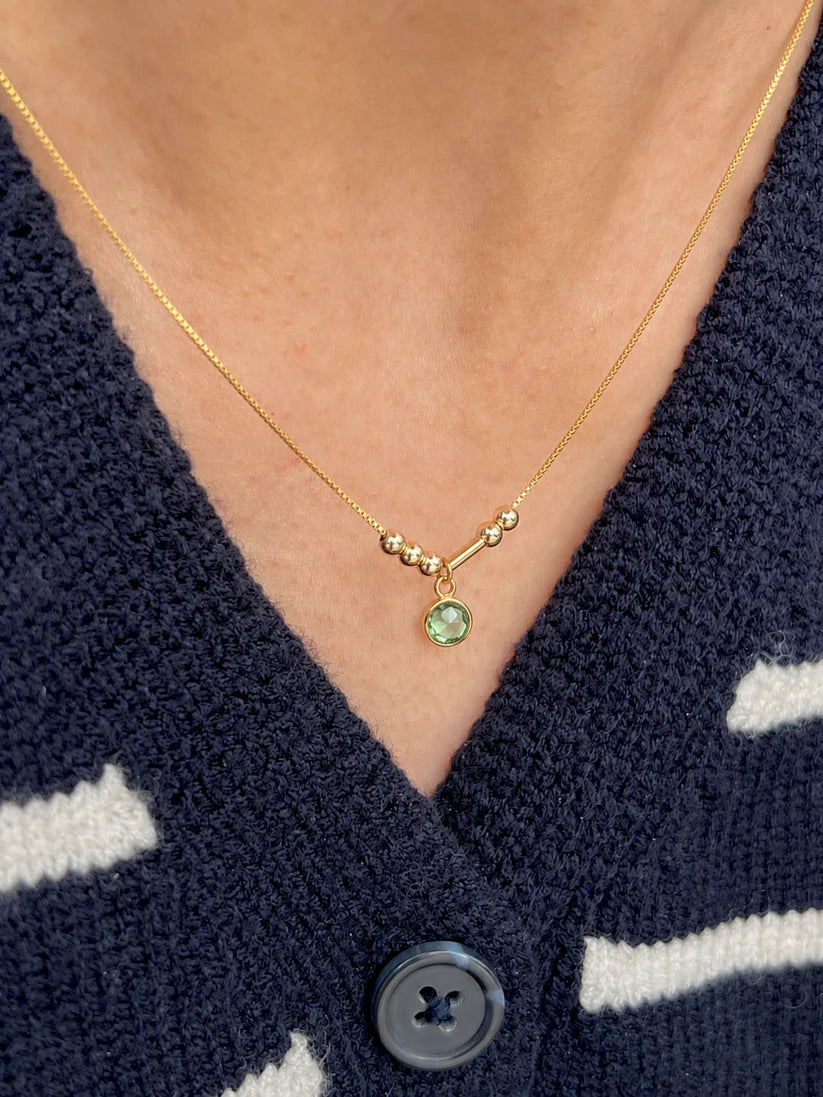 Personalized Birthstone Morse Code Necklace in 22K gold featuring a green birthstone charm, minimalist 4 mm Morse code beads, and an adjustable chain by Eraya Jewel.