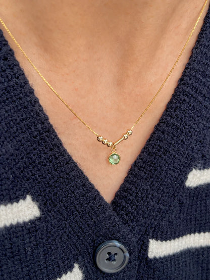 Personalized Birthstone Morse Code Necklace in 22K gold featuring a green birthstone charm, minimalist 4 mm Morse code beads, and an adjustable chain by Eraya Jewel.