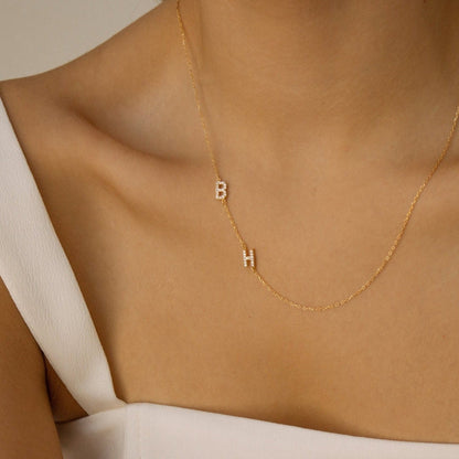 Personalized couple initial necklace with CZ B and H initials worn on a model