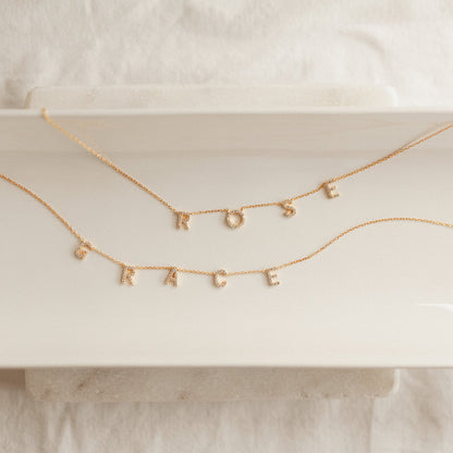 Flat lay of a custom Pavé Letter Name Necklace handcrafted with premium CZ letters for personalized everyday jewelry.