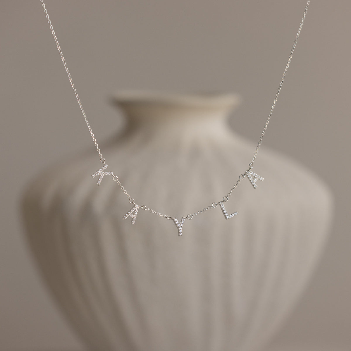 Personalized Pavé Letter Name Necklace in 22K gold finish featuring custom CZ pavé letters with a minimal everyday design by Eraya Jewel.