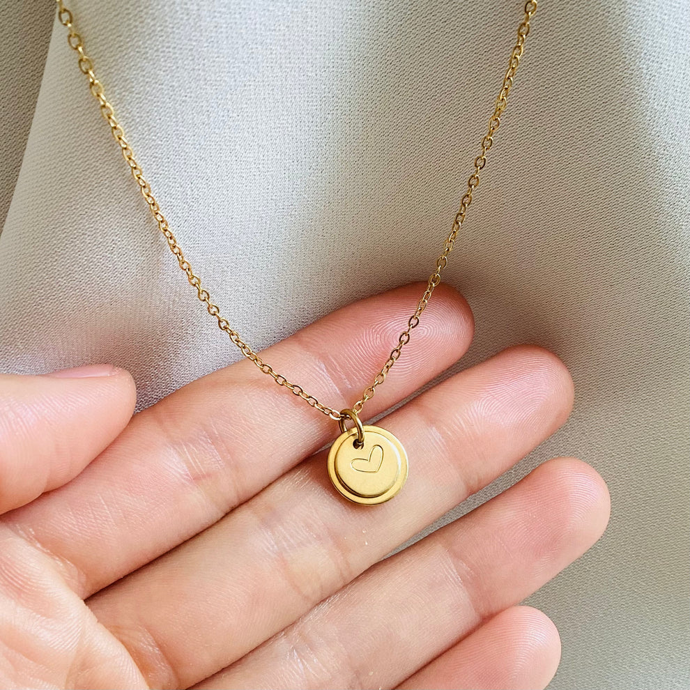 Minimalist heart initial pendant displayed on hand for her