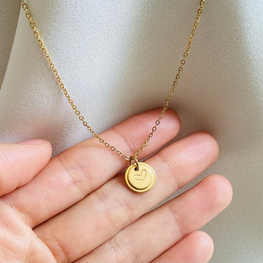 Minimalist heart initial pendant displayed on hand for her