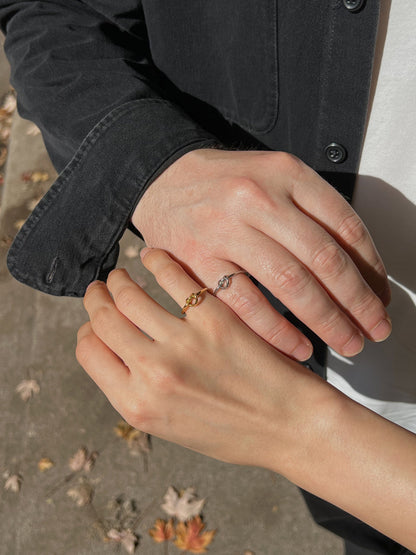 Modern gold and silver couple rings with knot design, symbolizing love and unity.
