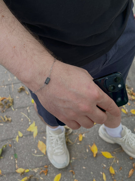 Men wearing silver his and her initial bracelet 
