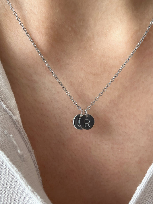 Model wearing silver initial coin pendant 
