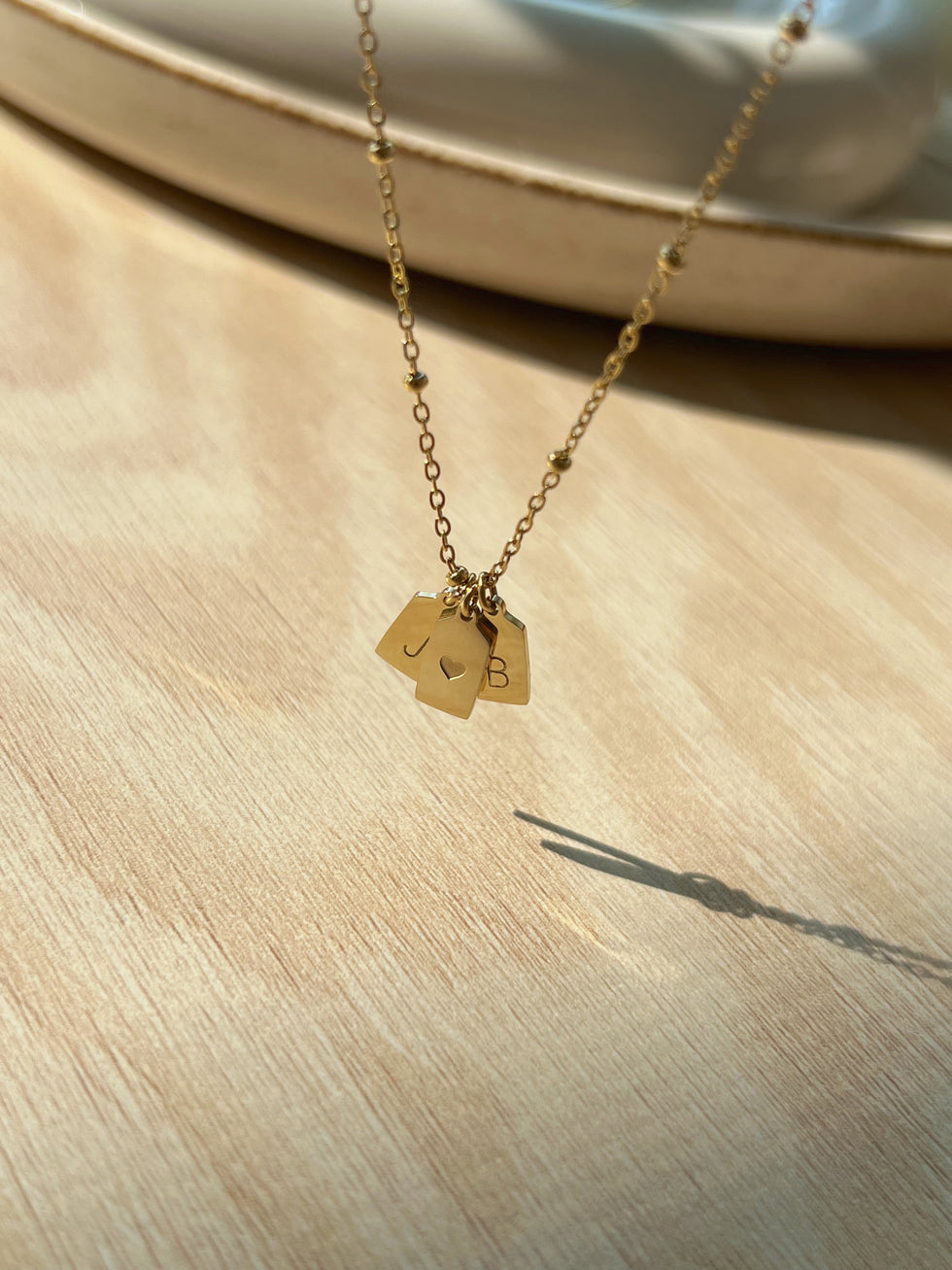 Close-up of gold polished heart pendant with custom initials