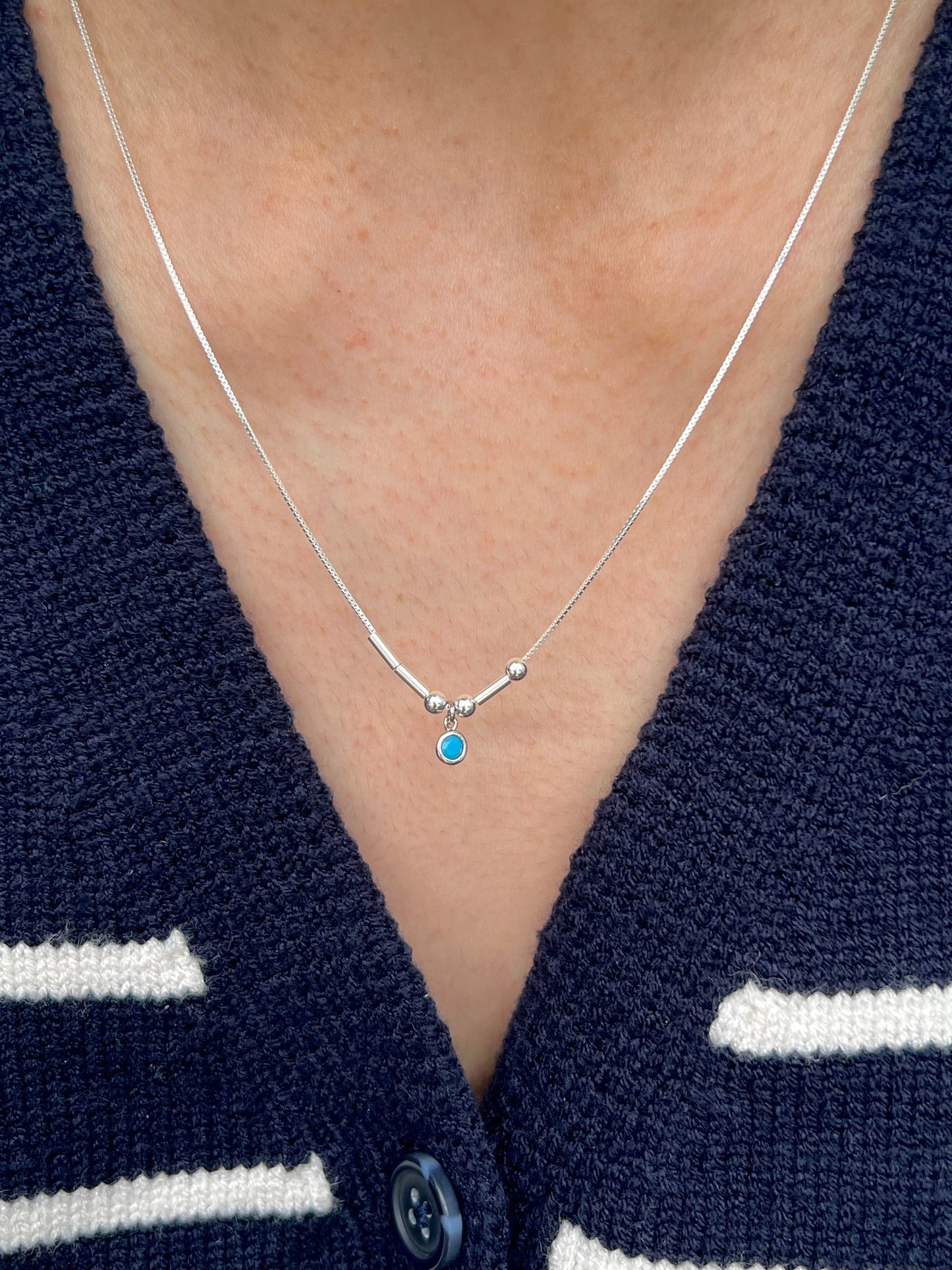 Model wearing silver initial morse code birthstone necklace 