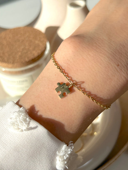 Model wearing gold puzzle initial bracelet 