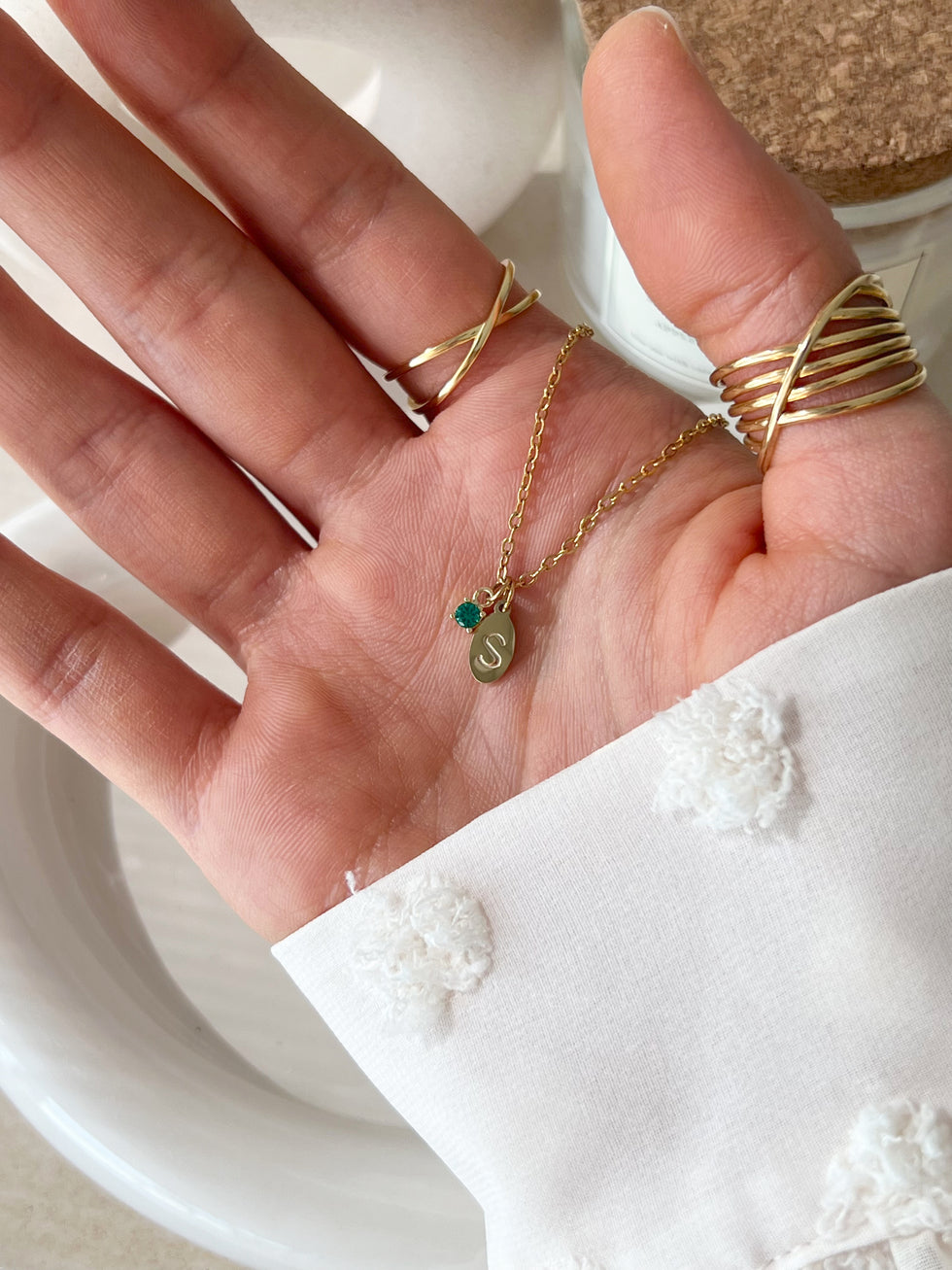 Close-up of petite initial pendant – dainty custom letter necklace on white background